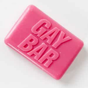 The GAY BAR - Soap is a rectangular pink bar embossed with "GAY BAR" in bold capitals on top, designed for a concept shop and photographed against a white background. Gate21.ee