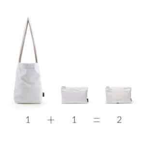 A black tote bag, "Feel Good Bag – Black," is displayed—curated with unique ideas from our gift shop. Mathematical symbols below it show 1 + 1 = 2. Gate21.ee