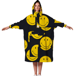 A person stands facing forwards with arms outstretched, wearing the oversized black Smiley hoodie decorated with bold yellow smiley face graphics and white trainers&mdash;an eye-catching Tallinn shopping find. Gate21.ee