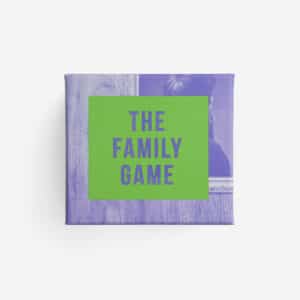 A purple box with a green square label on the front displays GAMES FOR GROWN-UPS in bold letters. The background has faint images of a person and picture frame, making it ideal for concept shop shelves or anyone seeking unique gift ideas. Gate21.ee