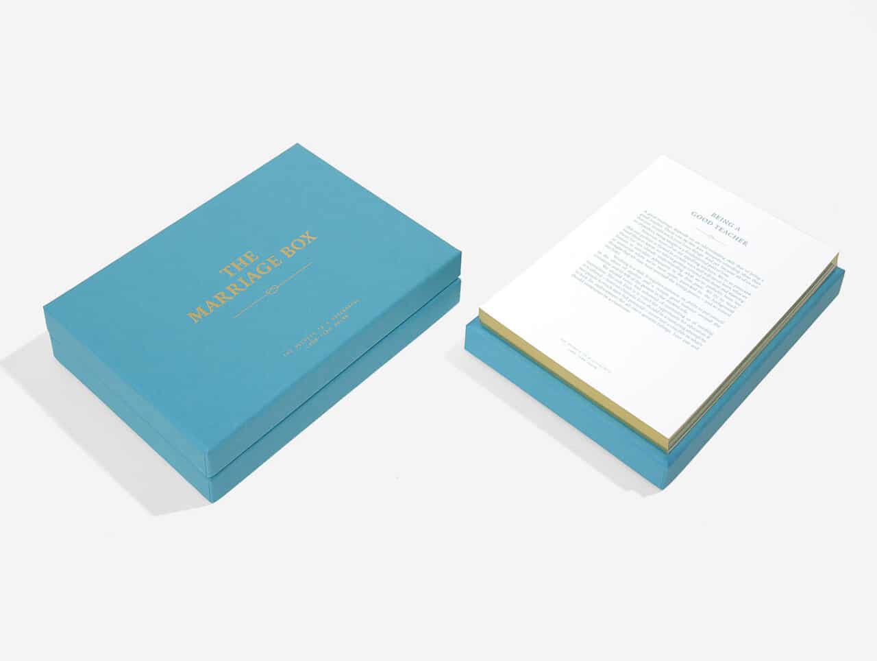 A blue box labelled Parents & Teenagers Game sits closed next to an open box with a stack of printed papers, each curated with unique ideas and featuring touches of Estonian design, all arranged on a white surface. Gate21.ee