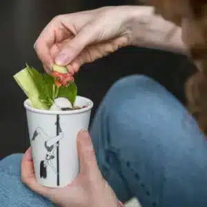A person dips a cucumber stick into the Pole Dancer Cup—found in a Tallinn concept shop—which features an illustration of a woman on a pole, making it look as though she’s holding the cucumber inside the cup. Gate21.ee