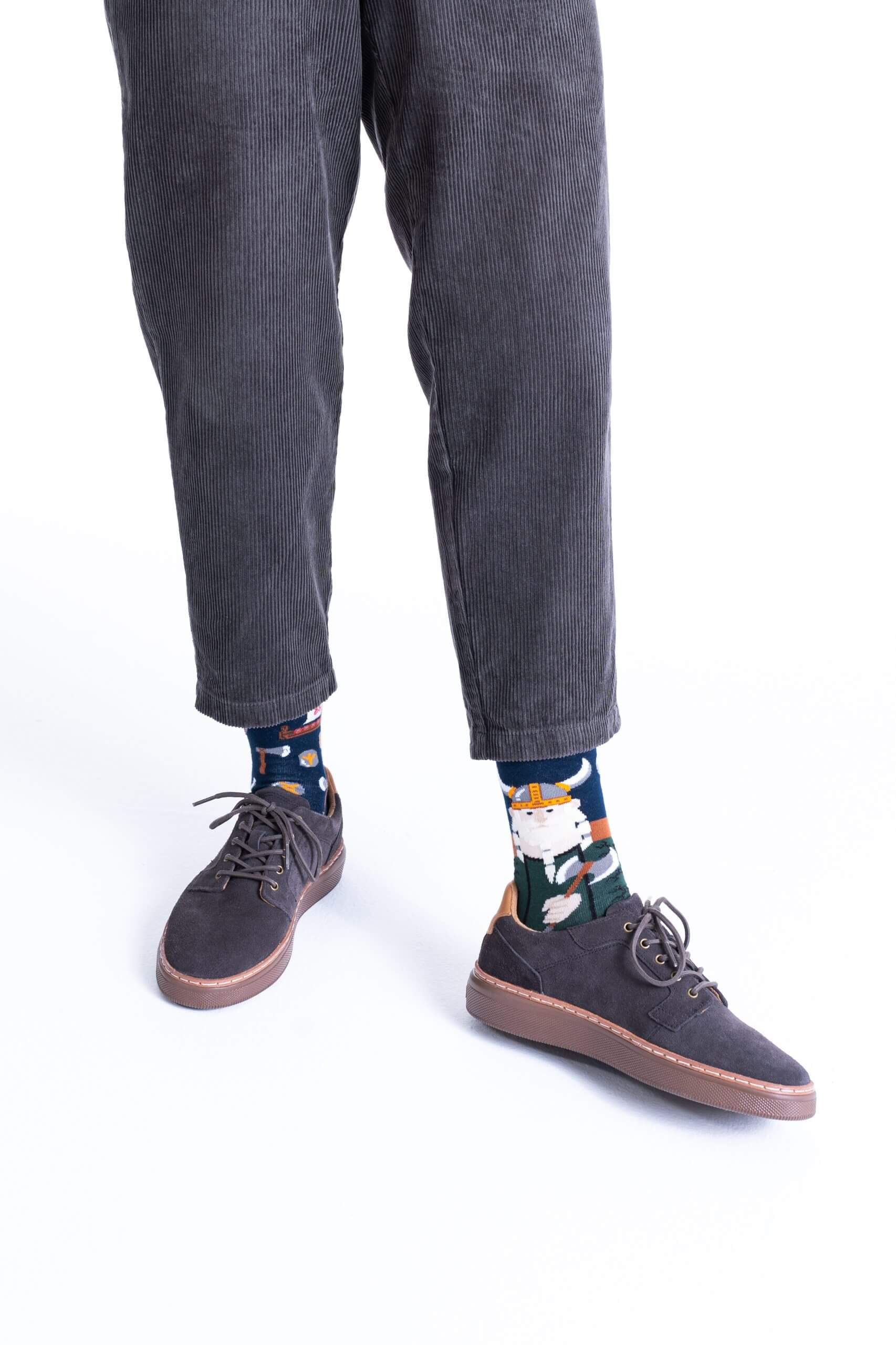 A person wears Fisher's Tale corduroy trousers, brown lace-up shoes, and cat-print socks—ideal for unique gift ideas or Estonian design inspiration whilst shopping in Tallinn. Image is cropped at the waist; only lower legs and feet appear. Gate21.ee