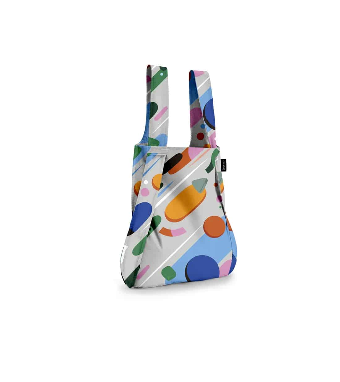 The Fruit Salad - Notabag is a reusable shopping bag with two handles, featuring a vibrant geometric pattern in blue, orange, green, and purple on white—ideal for Tallinn shopping or discovering unique finds at concept shops. Gate21.ee