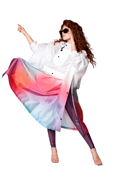 A person with long curly hair and sunglasses strikes a pose in Disco Dream—a loose white shirt, gradient skirt, shiny purple leggings, and open-toe heels—showcasing Estonian design vibes perfect for unique ideas at your favourite gift shop. Gate21.ee