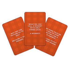 Three orange cards with white text display jokes from Dad Jokes - 100 of the Best. The centre card reads, “What do you call a donkey with only three legs? A wonkey!” Find quirky Estonian designs at your favourite Tallinn gift shop. Gate21.ee