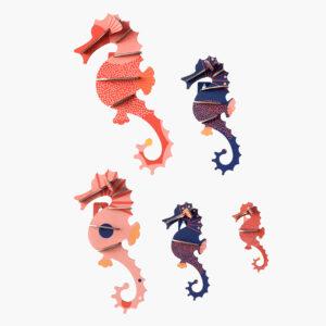 Sea Horses: Six vibrant, paper-cut seahorses in red, pink, navy blue, and purple—featuring printed and solid patterns—are displayed on white. A playful way to highlight your Tallinn shopping finds or celebrate Estonian design. Gate21.ee