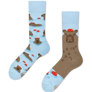 Capybara: Light blue socks with Estonian-designed cartoon capybaras in red hats—one sock shows capybaras in water, the other a big capybara face with a red hat—for unique, playful style. Gate21.ee