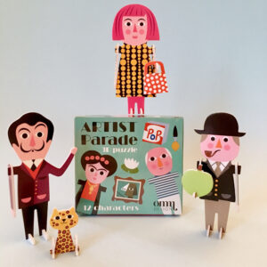 OMM - 3D Puzzles - Artists features 12 colourful, standing cardboard figures of artists and a polka-dotted cat around a display box. This curated set offers unique gift ideas or Tallinn souvenirs for art lovers. Gate21.ee