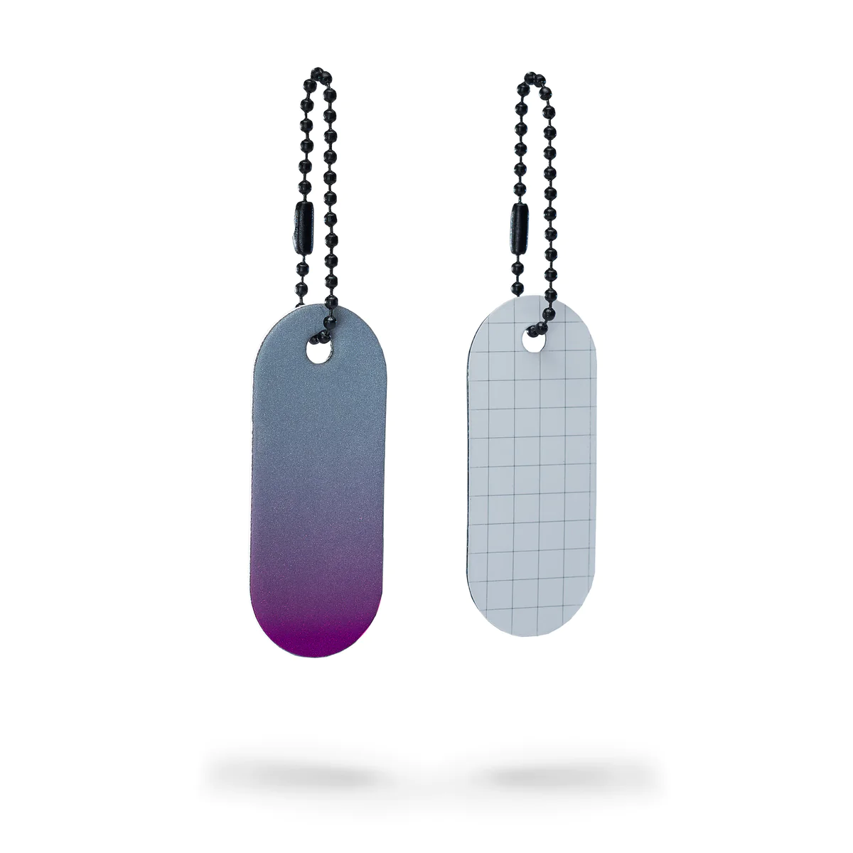 The Reflective Tag - Pink Fade features two oval keyring tags with beaded chains. One tag fades from dark grey to pink, while the reverse is white with a light grey grid&mdash;ideal for Tallinn shopping or as a chic gift shop find. Gate21.ee