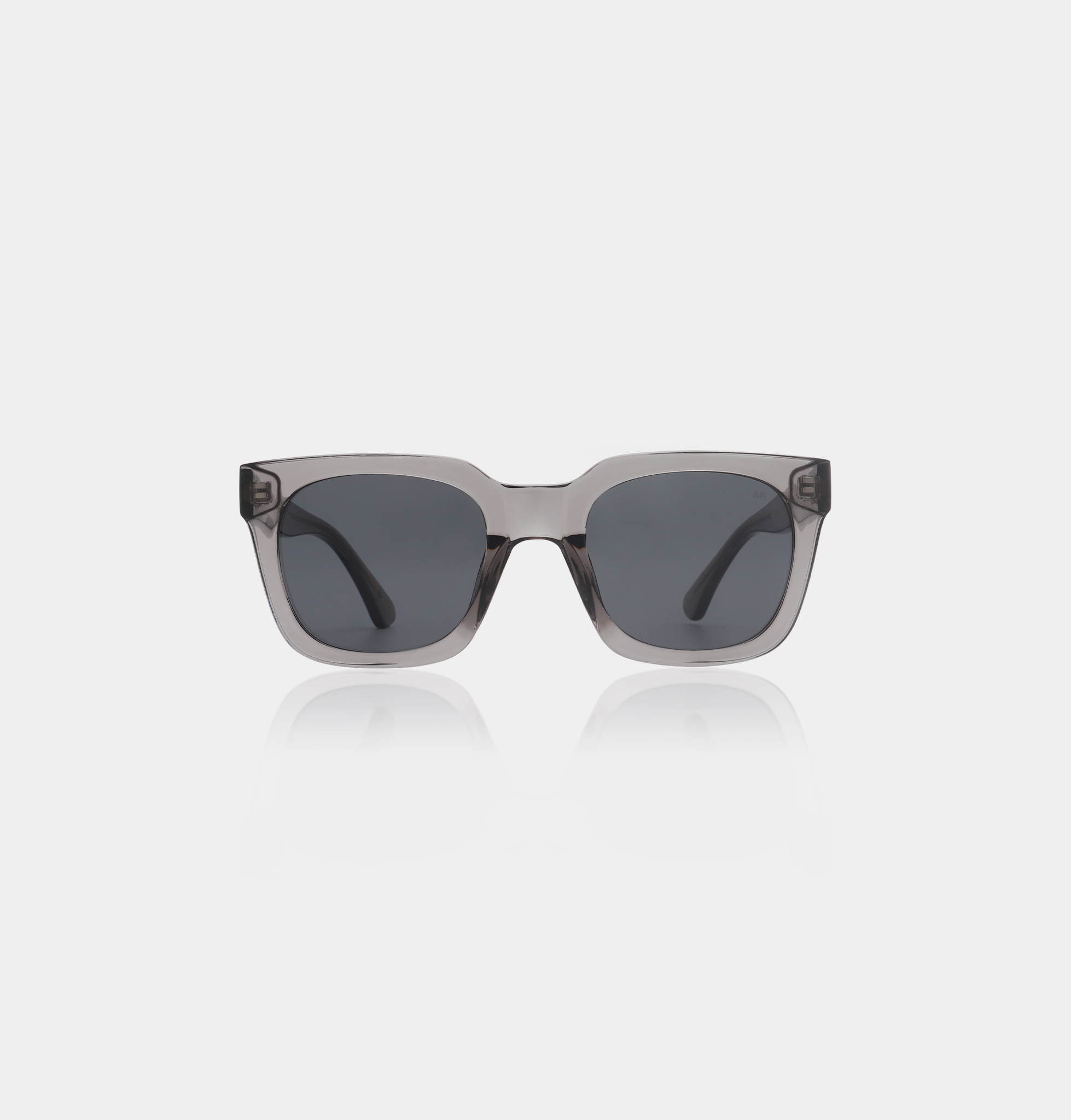 NANCY - Grey Transparent: Square-framed sunglasses with grey transparent rims and dark lenses, ideal for exploring creative ideas at a Tallinn concept store. Displayed on a plain white background. Gate21.ee