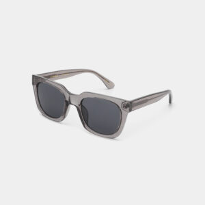 The NANCY - Grey Transparent sunglasses feature square, dark-tinted lenses and transparent grey plastic frames, exemplifying Estonian design, shown against a plain white background. Gate21.ee