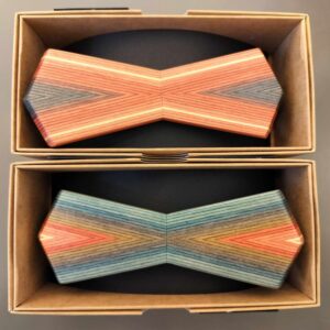 Two rectangular boxes display the Triibuvineer kikilips: a hexagonal, chevron-patterned accessory in vibrant orange, pink, green, and blue shades&mdash;an ideal gift from Tallinn for any shop or stylish shopper. Gate21.ee