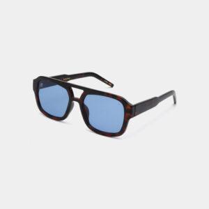 The KAYA sunglasses feature demi tortoiseshell frames and blue-tinted rectangular lenses, designed to inspire unique ideas, displayed on a plain light grey background. Gate21.ee