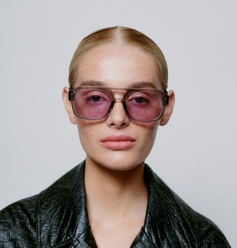 Wearing the KAYA - Grey Transparent sunglasses and a black textured jacket, this person with slicked-back blond hair looks straight at the camera—ideal for a shopping spree in Tallinn or discovering Estonian design gift shops. Gate21.ee
