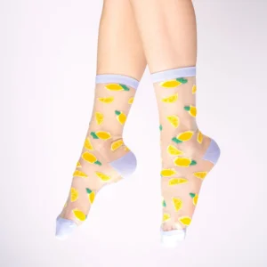 A pair of feet in Lemons - Transparent Socks, featuring yellow lemon wedges and green leaves, plus solid white toes, heels, and cuffs—a quirky gift or standout Tallinn shopping find on a simple light background. Gate21.ee