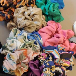 The Riivo - Crunchie collection features colourful scrunchies with diverse patterns and textures, neatly arranged on a desk beside a computer keyboard and mouse. Gate21.ee