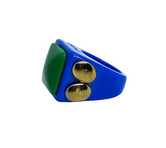 The Gucci - Ring features a blue band with a large green rectangular stone on top and two gold-coloured round studs on the side, making it a standout accessory for those looking for unique pieces. Set against a plain white background. Gate21.ee