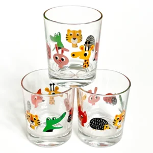 The OMM - Kids glasses - K&Otilde;IK set features three clear glasses adorned with colourful cartoon animal faces, including a tiger and giraffe&mdash;a playful example of Estonian design ideal for any curated gift shop display. Gate21.ee