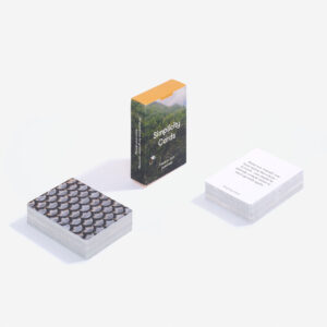 The Simplicity Cards deck stands upright in its box, with one stack featuring a textured pattern and another showing a white card with text—a minimalist Estonian design, ideal for concept shops or modern gift shops. Gate21.ee
