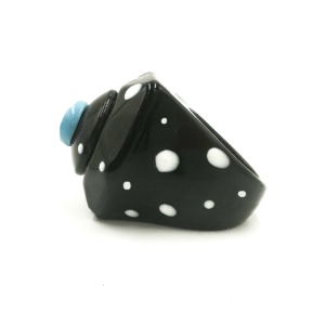 The Fluffy Back - Ring features a black band with white polka dots, an angular geometric design, and a small round light blue accent—an eye-catching piece inspired by Estonian design, ideal for unique gift shop finds. Gate21.ee