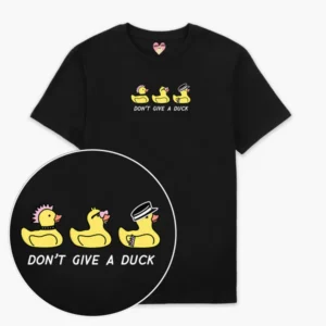 The Rubber Ducks T-Shirt - Black displays three yellow cartoon ducks with quirky accessories above the phrase "DON'T GIVE A DUCK" in white, making it a playful gift idea. A close-up highlights the detailed, fun design. Gate21.ee
