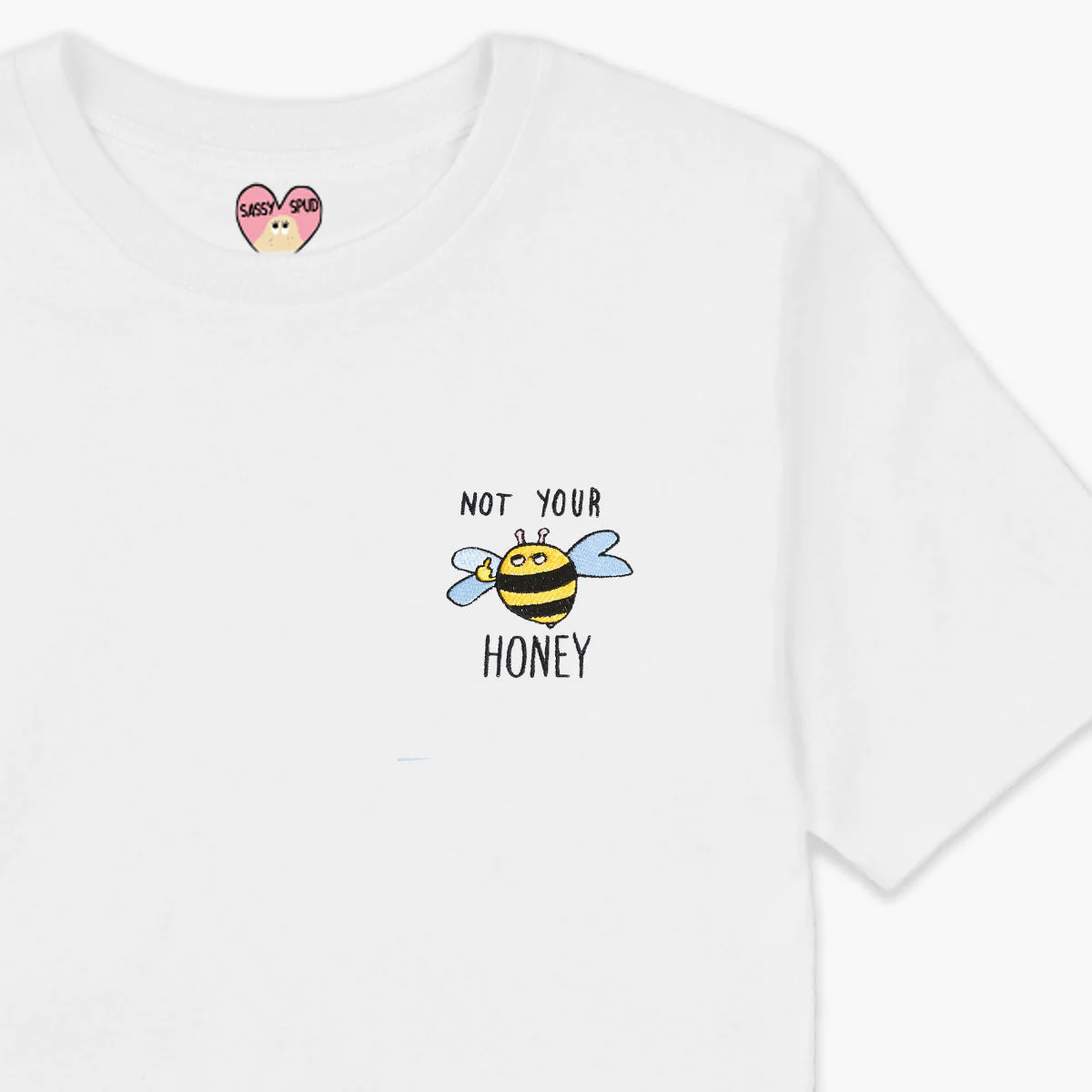 The Not your Honey T-Shirt - White features a cartoon bee and "NOT YOUR HONEY" text on the front, plus a pink heart-shaped SASSY SPUD tag inside the collar—perfect for concept shops or gift shops. Gate21.ee