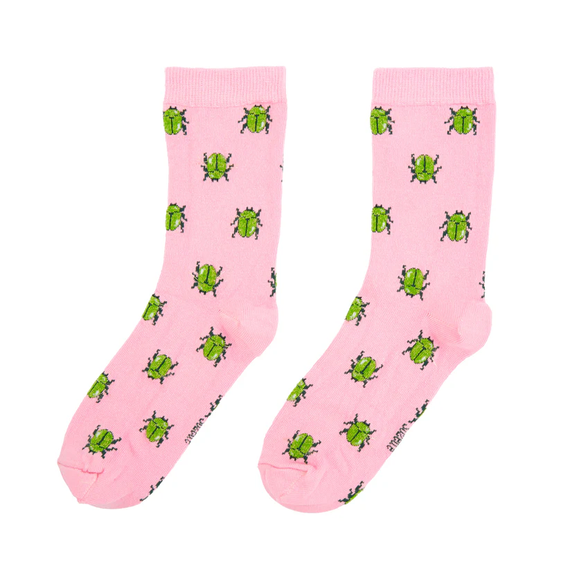 Beetles - Cotton Socks: Pink socks with a repeating pattern of green beetles and black legs. Displayed flat on a white background, they’re perfect for concept shops or gift shops seeking unique products. Gate21.ee