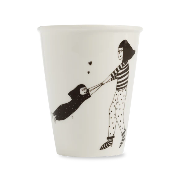The Spinning Around Cup from a Tallinn concept shop features a black-and-white illustration of a woman in stripes spinning a child in polka-dot pyjamas with heart accents—an ideal unique find for your Tallinn shopping. Gate21.ee
