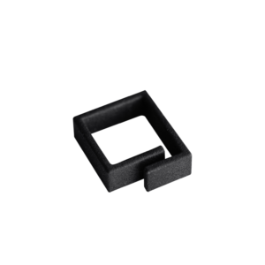 A black, square-shaped plastic object with an open side and a short protruding tab, reminiscent of unique ideas often found in Tallinn shopping concept shops, placed on a plain white background. Gate21.ee