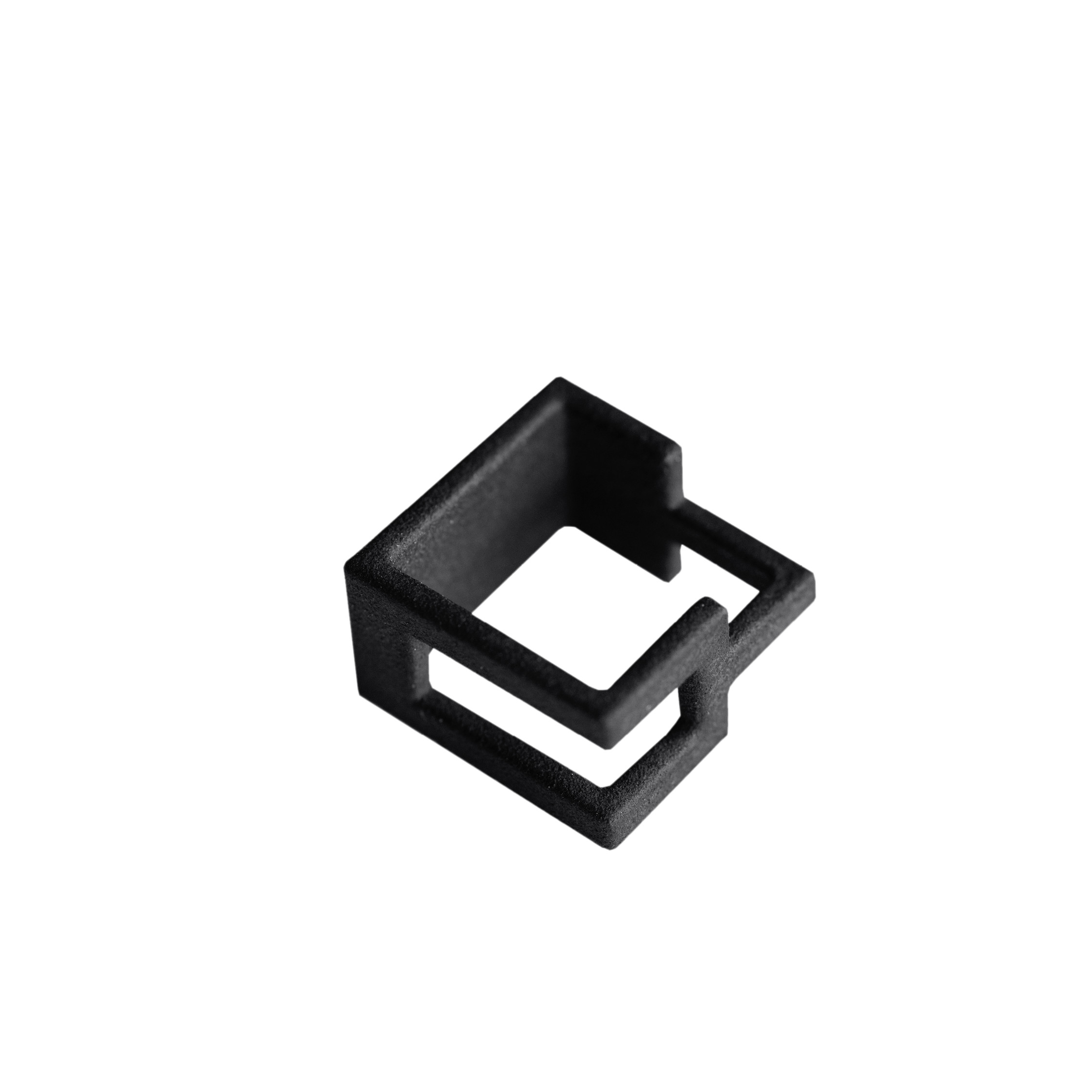 A black, rectangular, open-frame plastic or metal clip with geometric cut-outs—showcasing Estonian design—is displayed against a plain white background. Gate21.ee