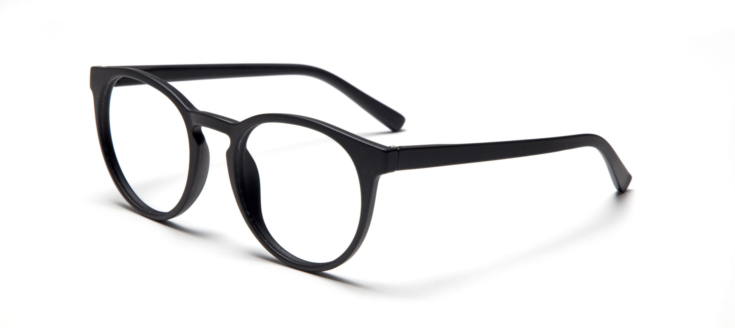The PAPILLON - Black eyeglasses, featuring round clear lenses and designed in Estonia, rest on a white surface angled right—an elegant statement for any concept shop. Gate21.ee
