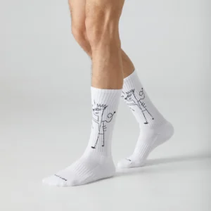 A person wears Basquiat TKO - Athletic white crew socks featuring a black line drawing of a crowned figure with a heart—perfect for anyone seeking curated style and unique ideas from your favourite concept shop. Gate21.ee