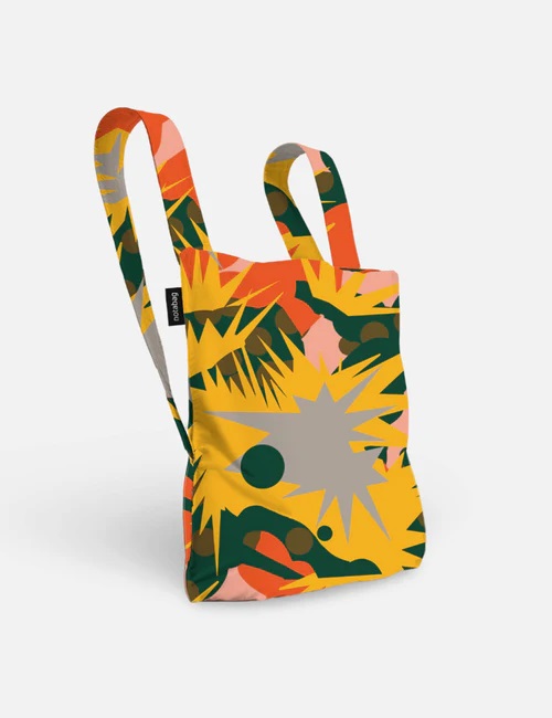 The Spark is a reusable fabric tote bag with two handles, featuring curated Estonian design in bold yellow, green, orange, and pink on white. Its rectangular shape and small black side tag make it perfect for shopping in Tallinn. Gate21.ee