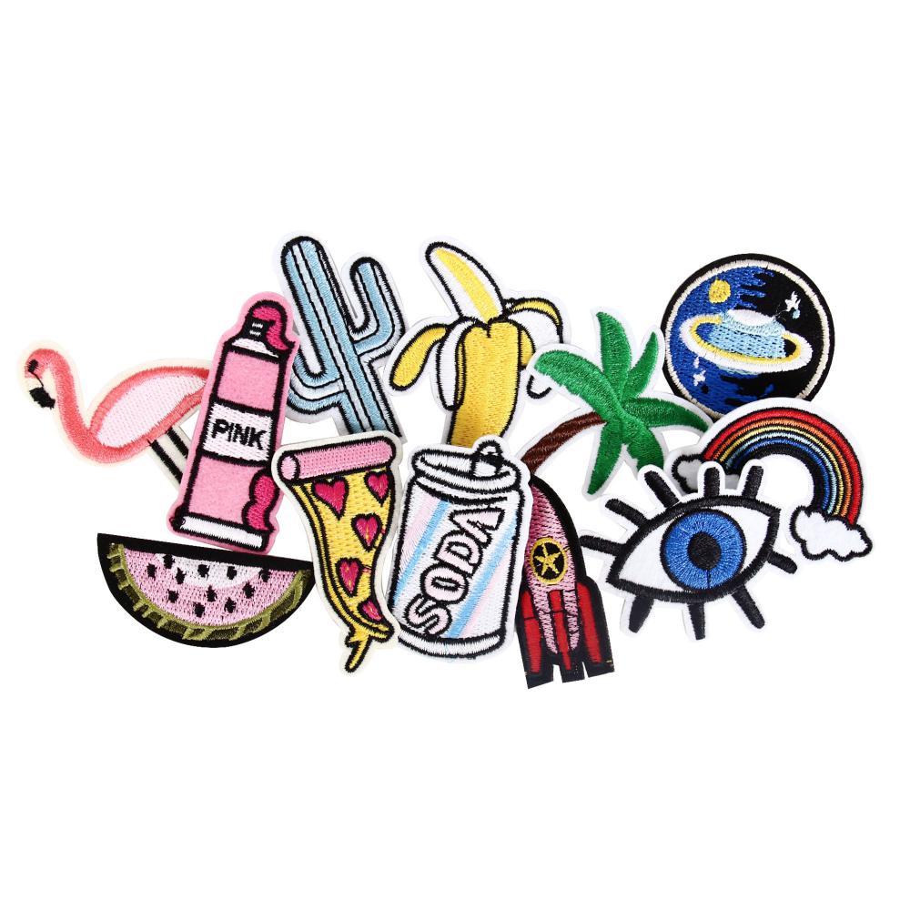 Patches: Colourful embroidered patches inspired by Estonian design, featuring flamingo, watermelon slice, pizza slice, and fizzy drink can—great souvenirs from Tallinn or fun finds at local gift shops. Gate21.ee