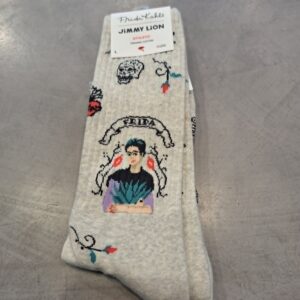 A pair of light-coloured &ldquo;Frida Viva Mexico - Athletic&rdquo; socks from Jimmy Lion, featuring a Frida Kahlo portrait with colourful accents and the visible &ldquo;Frida Kahlo by Jimmy Lion&rdquo; label, displayed on a grey textured surface. Gate21.ee