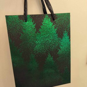 Giftbag: A black gift bag with green tree silhouettes, hanging by two black handles&mdash;ideal for unique ideas while shopping in Tallinn or as a special touch from your favourite gift shop. Gate21.ee