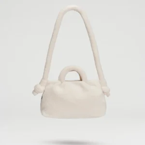The Mini Ona Sherpa Bag - Sand is a cream-coloured, plush handbag with a soft texture, featuring a short handle and long shoulder strap. An Estonian design piece, it's displayed against a plain white background. Gate21.ee