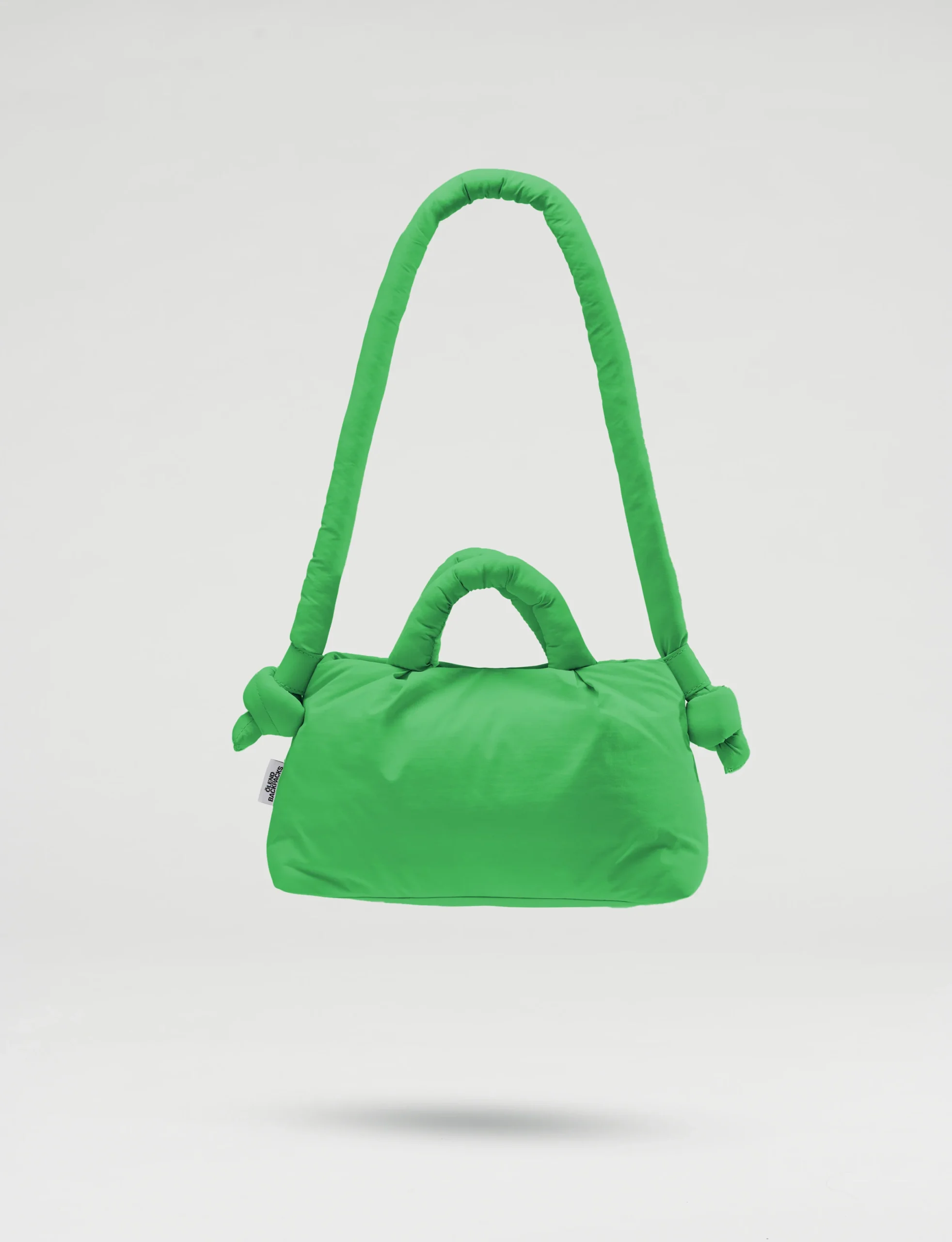 The Mini Ona Soft Bag - Green is a padded handbag with one short and one long handle, displayed against a white background. Curated for modern shoppers, this chic accessory stands out in Tallinn shopping and concept store collections. Gate21.ee