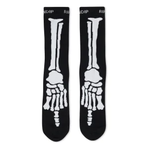 The Skelly Nerm Socks - Black feature a white skeleton foot and leg bone design with “RIPNDIP” and “RIP” on the cuffs—an eye-catching, quirky gift or souvenir from your favourite Tallinn shop. Gate21.ee