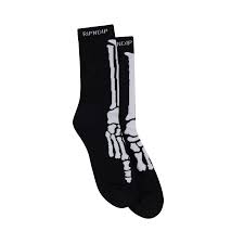 The Skelly Nerm Socks - Black feature a white skeleton foot and leg bone design on black, shown side by side on a white background—perfect for adding quirky flair from your favourite gift shop or Tallinn shopping trip. Gate21.ee