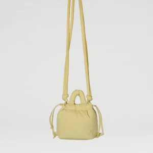 The Micro Ona Soft Bag - Lime is a small, pale yellow handbag featuring a long shoulder strap, short handles, and side drawstring details—perfect for curated concept shop collections or anyone after a distinctive accessory. Gate21.ee
