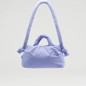 The Mini Ona Soft Bag - Lilac, a padded light purple handbag with a thick shoulder strap and two short handles, is displayed against a plain grey background—ideal for Tallinn shopping or as a charming gift shop find. Gate21.ee