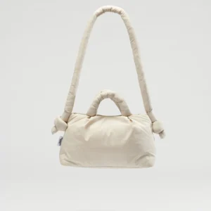 The Mini Ona Soft Bag - Sand is a cream-coloured, padded handbag with a long, rounded shoulder strap, two short handles with knot details, and Estonian design elegance—displayed against a plain light background. Gate21.ee