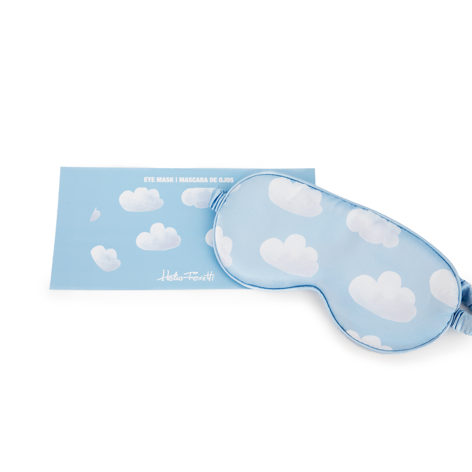 A light blue Eye Mask – Cloudy Dream with white cloud patterns lies beside matching packaging that reads EYE MASK | MÁSCARA DE OJOS and Hello From Eti—highlighting Estonian design and perfect for any gift shop. Gate21.ee