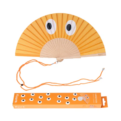 The "Eyes" fan is a handheld folding fan with an orange design and two cartoon eyes, an attached orange string, plus a matching box with multiple cartoon eyes—great for Tallinn shopping or as a unique local gift. Gate21.ee