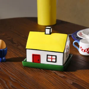 The Haines butter dish features a ceramic house with a yellow roof, red door, and red-trimmed windows on a green base&mdash;an adorable piece of Estonian design to adorn your table or pick up when shopping in Tallinn. Gate21.ee
