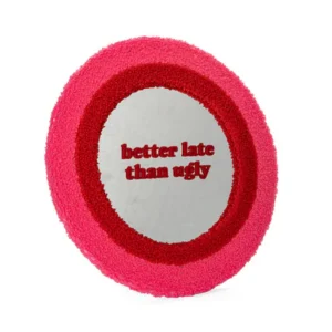 The "Better late than ugly!" mirror features a round design with a textured pink and red frame and the bold red phrase “better late than ugly” printed on its surface—perfect for concept shops or gift shops. Gate21.ee