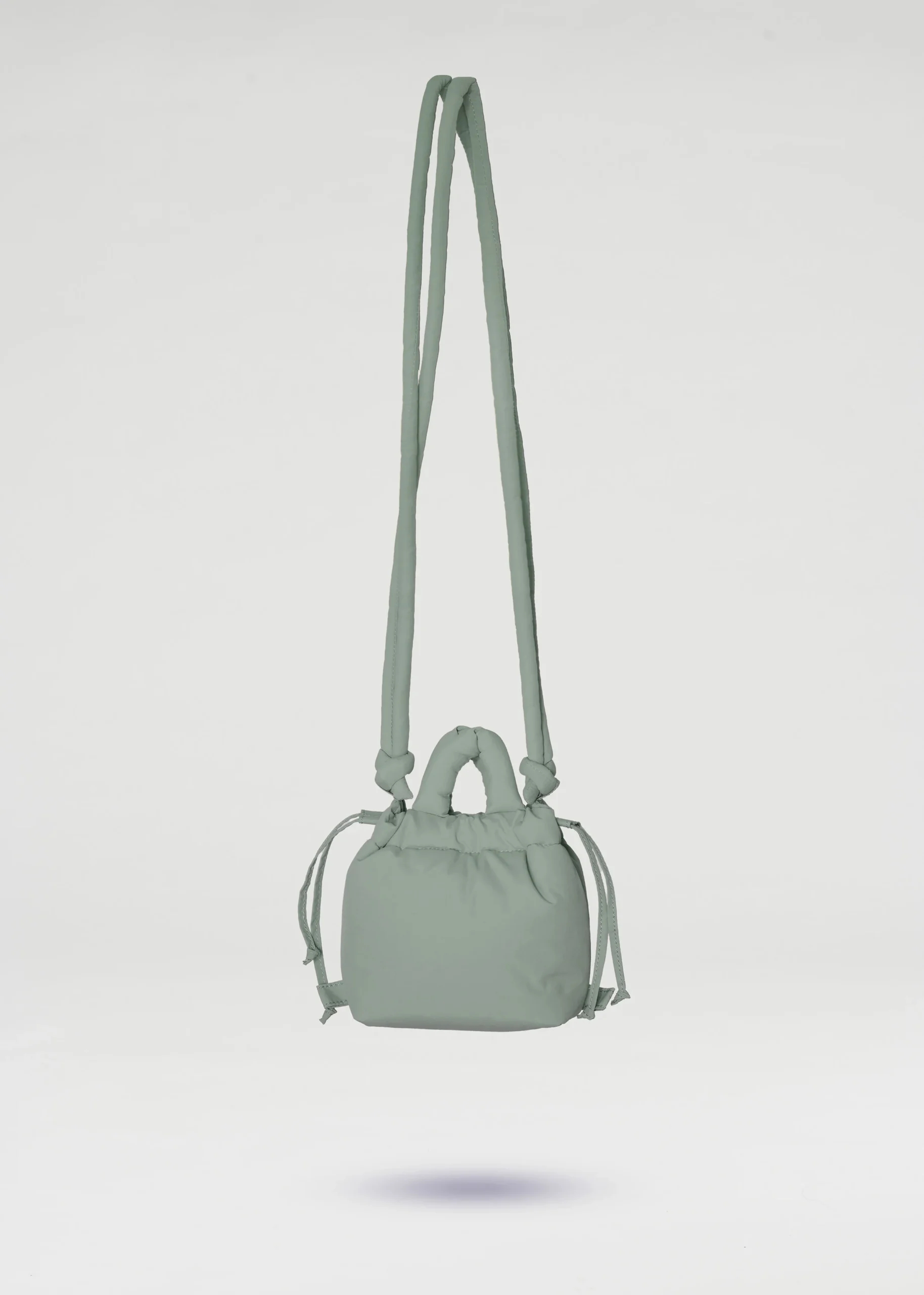 The Micro Ona Soft Bag - Sage is a small, light green rectangular crossbody with long strap, short handles, and drawstring sides—ideal for Tallinn shopping or unique style ideas—shown against a plain white background. Gate21.ee