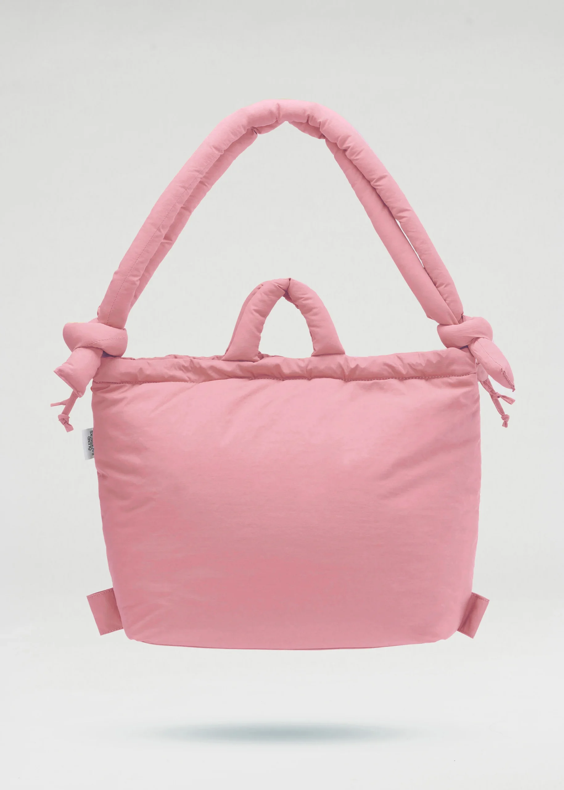 The Ona Soft Bag - Pale Pink is a padded tote with two short handles and two knotted shoulder straps, exemplifying unique Estonian design, displayed against a plain white background. Gate21.ee